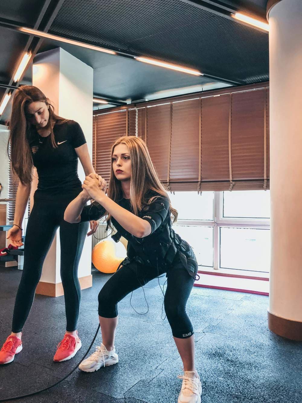 Coach sportif accompagnant une cliente pendant un entraînement personnel